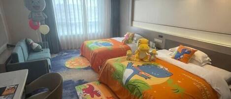 A hotel room with two beds, a sofa, a table, and a chair.