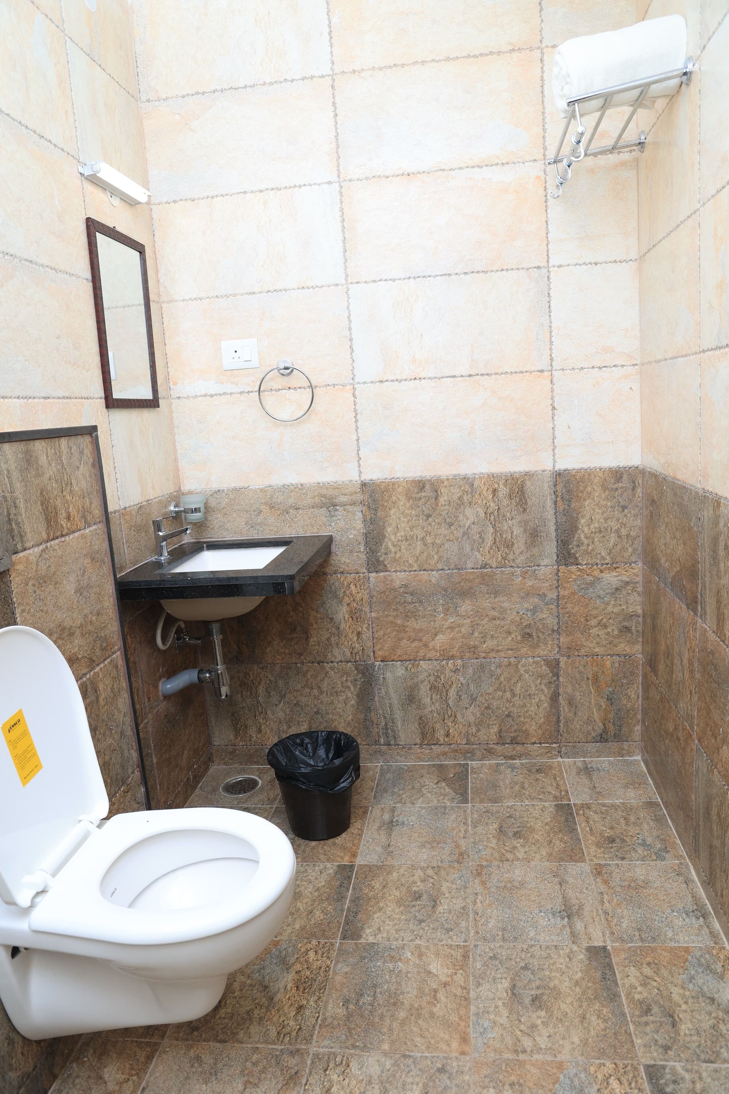 A small bathroom with a toilet, sink, and shower area.