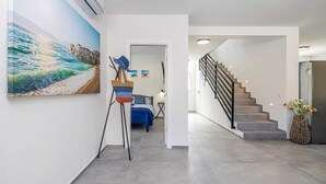 A modern interior with a staircase, a bed, and a painting of a beach scene. - Villa KATHARINA with private pool (Žgaljići)