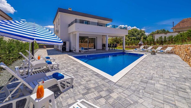 A modern two-story house with a swimming pool, outdoor seating, and a covered patio area. - Villa KATHARINA with private pool (Žgaljići)