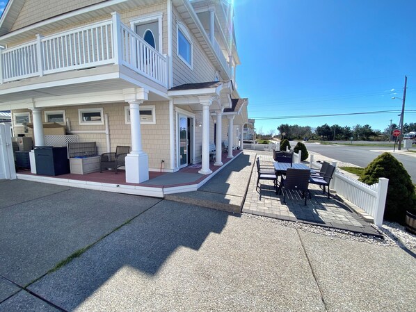 A two-story building with a covered patio area featuring outdoor seating. - Steps 2 Beach- Family, Walk 2 Downtown, Close 2 AC. (Brigantine)