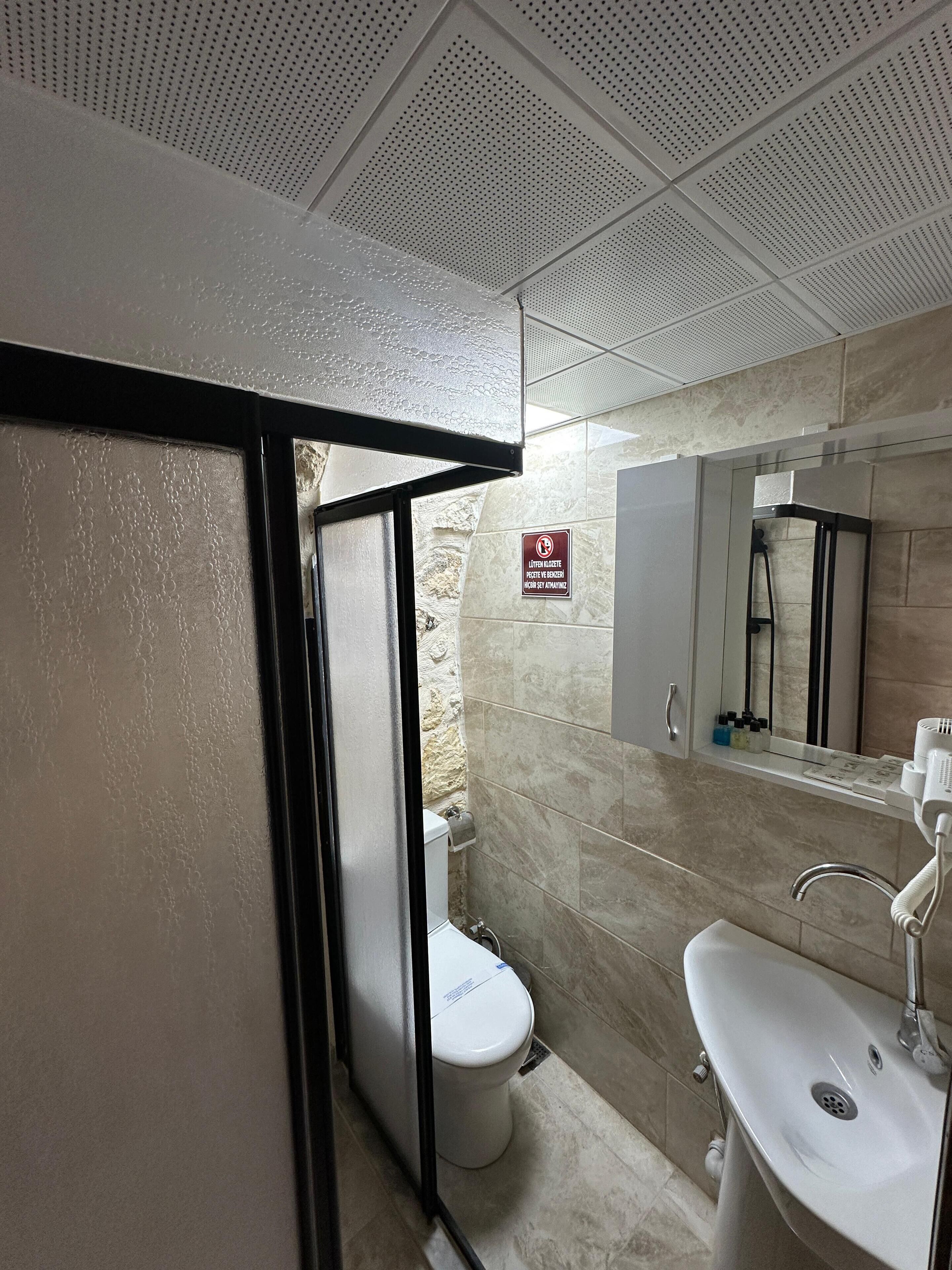 A bathroom with a shower, toilet, and sink.