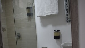 A bathroom with a glass-enclosed shower, a toilet, a sink, and a trash can. - Loft Entero Privado 25 Mts (Medellín)