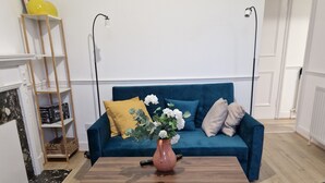 A living room with a blue sofa, a wooden coffee table, a colorful rug, and a world map on the wall. - A lovel one bedroom.  (London)