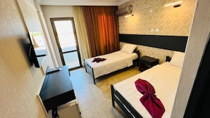 A hotel room with two single beds, a desk, a chair, and a small table. - Blue Golden Sea (Kusadasi)