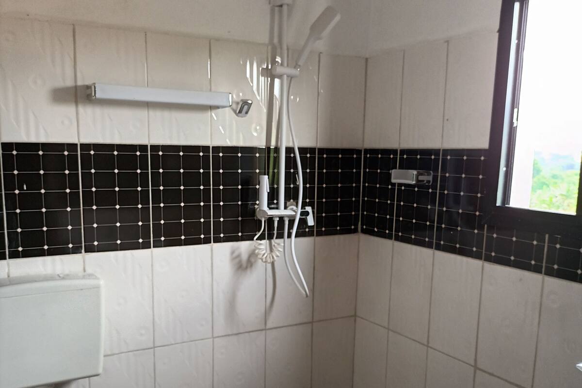 A bathroom with a toilet, sink, and shower.