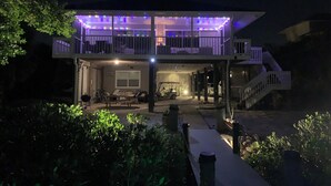 Une maison à deux étages dotée d’un balcon, d’une terrasse couverte et d’un escalier menant à l’étage supérieur.