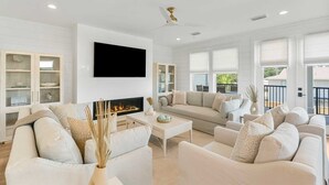 Un salón espacioso con chimenea, asientos cómodos y ventanas amplias.