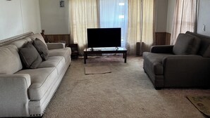 A living room with two sofas, a coffee table, and a television. - Country fishing paradise (Moore Haven)