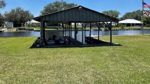 A covered pavilion with a roof, a dock, and a flagpole with an American flag. - Country fishing paradise (Moore Haven)