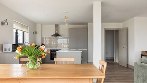Une cuisine moderne dotée d’un îlot central, d’une table à manger en bois et de chaises.