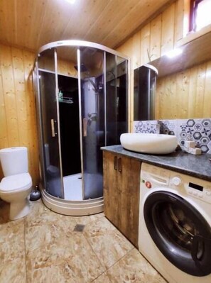 Bathroom features a toilet, shower stall, sink, and washing machine.