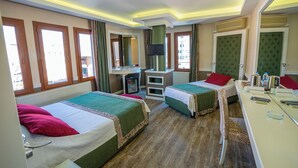 A hotel room with two beds, a desk, a mirror, and a television. - Berrak Otel (Salihli)