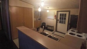 Una cocina compacta con una isla central, microondas y estufa.