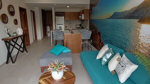 A modern living room with a sofa, a coffee table, and a dining area with chairs.
