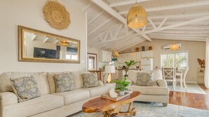 Un salon spacieux avec un grand canapé, une table basse en bois et un tapis à motifs.