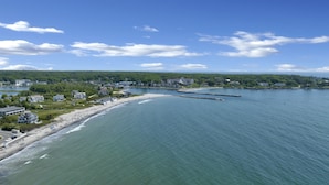 An aerial view of a coastal town with a beach, houses, and a pier. - Ocean views on Gooch's Beach! (Kennebunk)