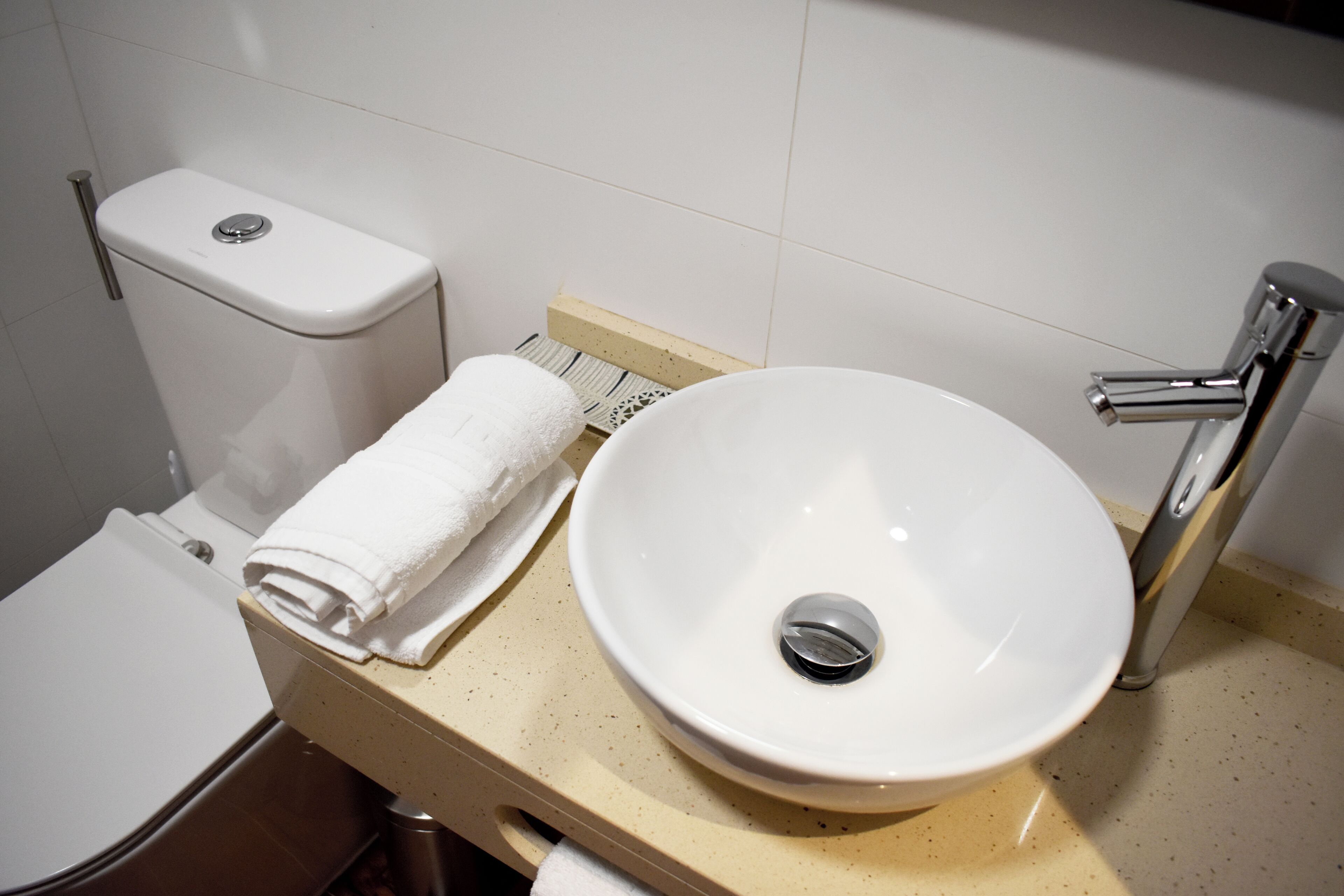 Un bagno con il water, un lavandino e un portasciugamani.