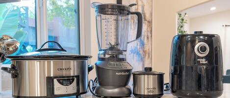 Een keuken met een Crock-Pot, een Nutribullet blender en een Magic Bullet.