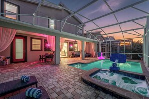 A covered outdoor area with a swimming pool, lounge chairs, and a patio with a table and chairs. - Luxury Villa,Theater,Pool,Spa,RESORT (Davenport)