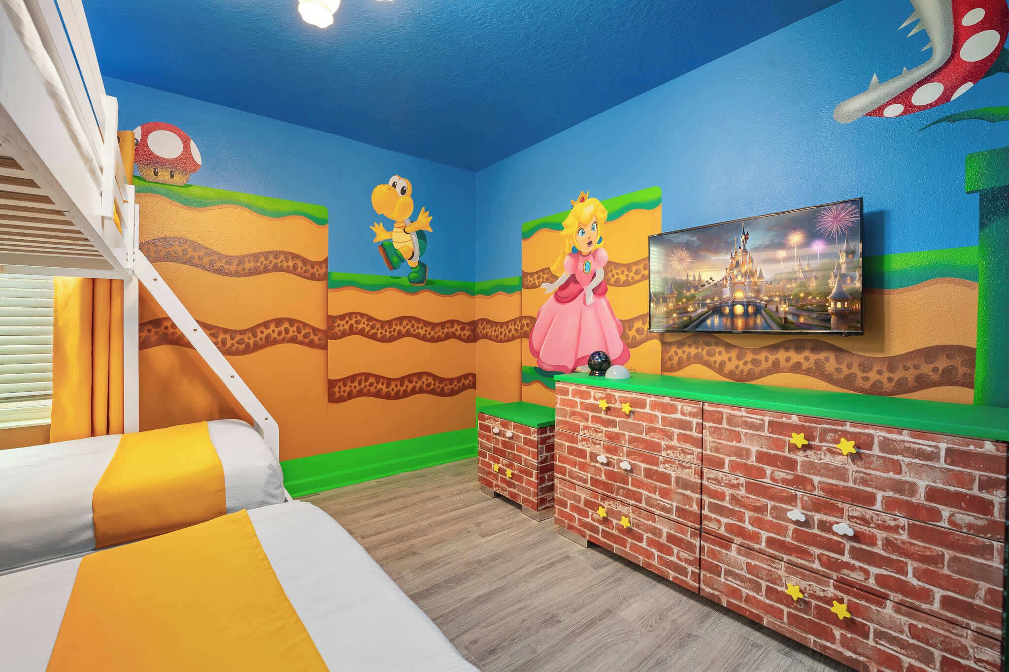 A room with a bed, a brick-patterned dresser, a TV, and a mural with characters.