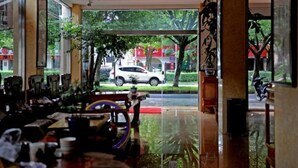 A hotel lobby with a large glass window, a reception desk, and a view of the street outside.