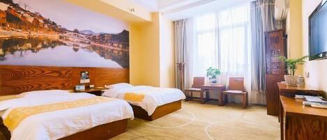 A hotel room with two beds, a desk, a chair, a TV, and a large painting on the wall.