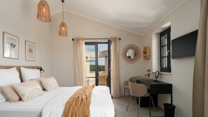 Een slaapkamer met een bed, een bureau en uitzicht op de omgeving.