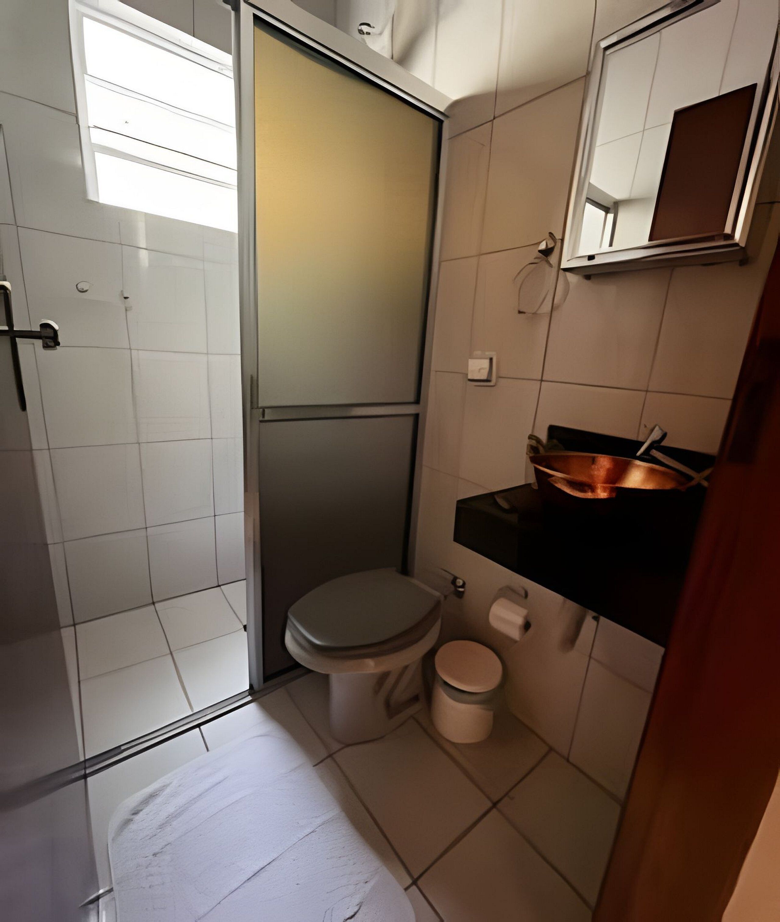 A compact bathroom with a toilet, bidet, and a small sink area.