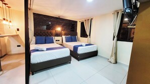 Habitación de hotel con dos camas, cabecera de mármol y mesita de noche.