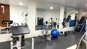 A gym with exercise equipment, a blue exercise ball, and a mirror. - Urban Serenity: Cozy 1Bedroom apartment. (Quito)