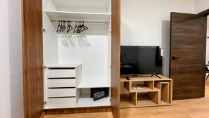 A walk-in closet with hanging space, a TV, and a wooden desk. - Urban Serenity: Cozy 1Bedroom apartment. (Quito)