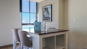 A modern kitchen with a white countertop, two barstools, and a framed picture on the wall. - La Mar Miraflores by Wynwood House (Lima)