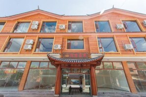 A building with a traditional architectural style, featuring a prominent entrance with a tiled roof. - Lugu Manor Hotel (Ninglang)