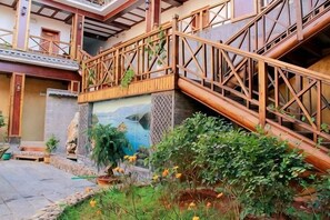 Una escalera de madera que lleva a un balcón con vistas a un paisaje montañoso.