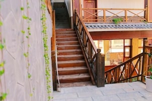 Una escalera de madera con barandilla que sube a un nivel superior.