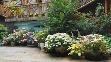 Un patio con plantas en macetas y un puente de madera.