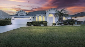 A modern house with a well-maintained lawn, a garage, and a large driveway.