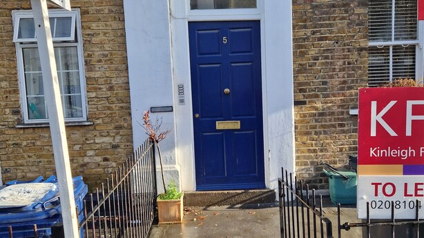 A narrow stairway leading to a blue door with the number 5, flanked by a metal fence and a 'TO LET' sign. - A studio overbooking the city  (London)