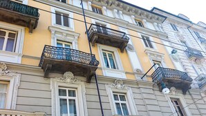 A multi-story building with ornate balconies, large windows, and a sign for "Piazza Castello." - Apple House al Duomo by Wonderful Italy (Turin)