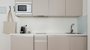 A modern kitchen with a microwave, coffee maker, and sink. - Sol Studio IV – In the City Center (Madrid)
