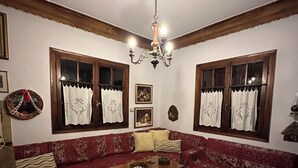 A cozy living room with a red sofa, a wooden coffee table, and a chandelier.