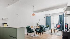 En moderne opholdsstue med et køkken, spiseplads og siddeområde.