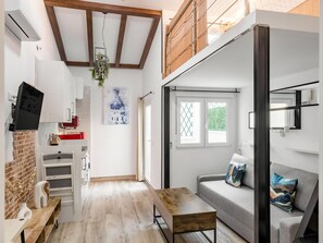 A modern kitchen with white cabinets, a hanging plant, and a red appliance. - Madrid VIllaverde IV - Studio with patio and AC (Madrid)
