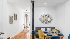 Een eethoek met een ronde tafel, blauwe stoelen en een decoratieve spiegel aan de muur.