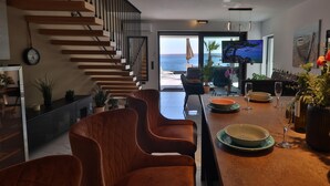 A modern kitchen with a central island, wooden staircase, and a view of the sea. - Lovely home in Baric Draga (Baric Draga)