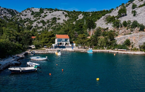 Enjoy serene views of the ocean from this hillside retreat, featuring a dock and opportunities for boating.