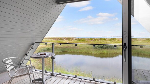 A balcony with a view of a lake and distant landscape. - 3 bedroom stunning home in Vestervig (Vestervig)