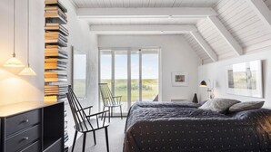 A bedroom with a bed, a desk, and a chair. There is a window with a view of the outdoors. - 3 bedroom stunning home in Vestervig (Vestervig)