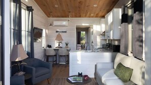 A modern interior with a living area, dining space, and kitchen. - Home w/ 2-Story Windows + Studio | 70+ Amenities (Richmond)